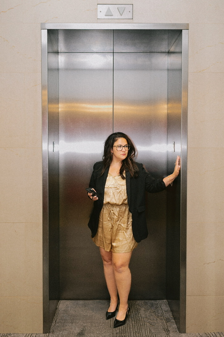 Aly Carter standing in an elevator holding her phone